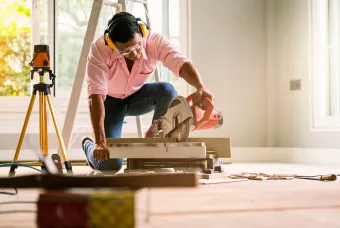 DIY man cutting floorboards