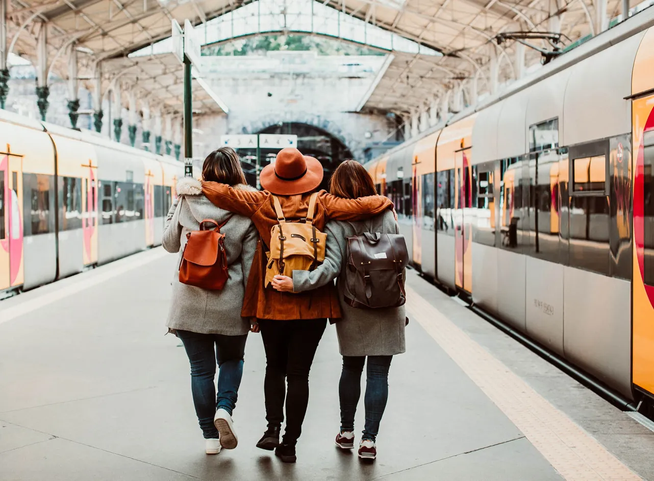friends at train station wearing backpacks